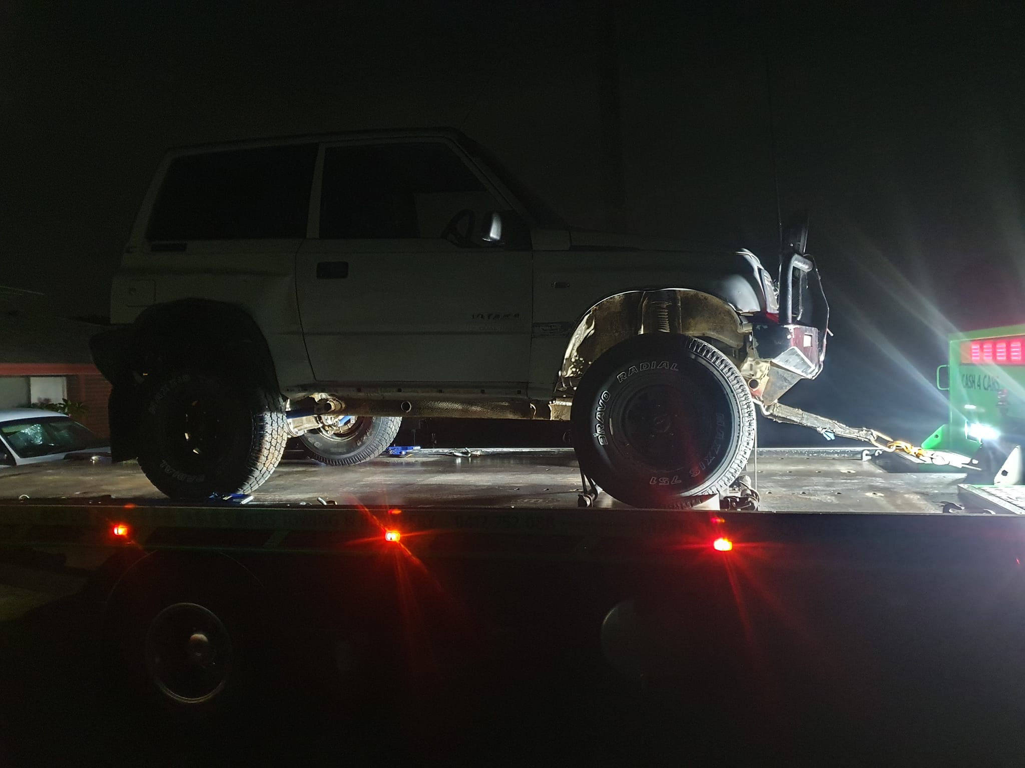 Tow truck providing roadside assistance at night in Perth